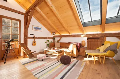 a living room with a vaulted ceiling with windows at The Loft in Saint-Gervais-les-Bains