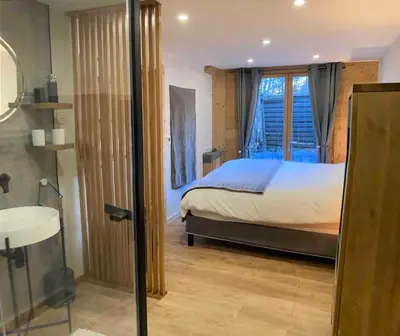 a bedroom with a bed and a bathroom with a window at Chamlomy in Chamonix-Mont-Blanc