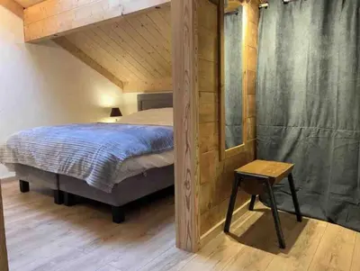a bedroom with a canopy bed and a table at Chamlomy in Chamonix-Mont-Blanc