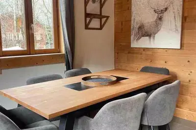 a dining room table with chairs and a picture of a deer at Chamlomy in Chamonix-Mont-Blanc