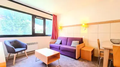a living room with a purple couch and a table at Residence De La Foret - Appartement confortable · Au pied des pistes MAE-9991 in Magland