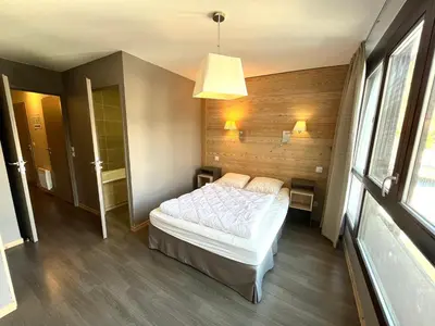 a kitchen with wooden cabinets and a counter top at Appartement skis aux pieds à Flaine avec parking et piscine - FR-1-425-227 in Arâches-la-Frasse