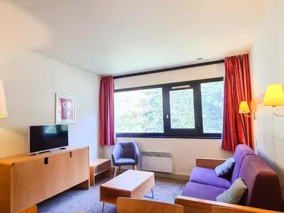 a living room with a purple couch and a tv at 2 Pièces Confort au Pied des Pistes, Flaine - FR-1-425-228 in Arâches-la-Frasse