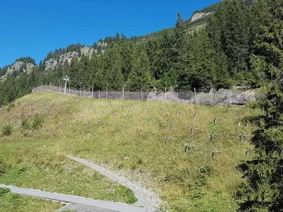 a fence on the side of a hill with a road at 2 Pièces Confort au Pied des Pistes, Flaine - FR-1-425-228 in Arâches-la-Frasse