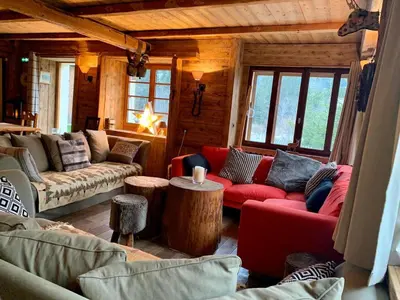 a living room with couches and tables in a cabin at Chalet familial et chaleureux in Les Contamines-Montjoie