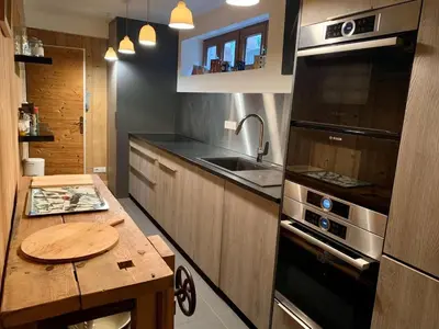 a kitchen with a wooden table and a stove at Chalet familial et chaleureux in Les Contamines-Montjoie