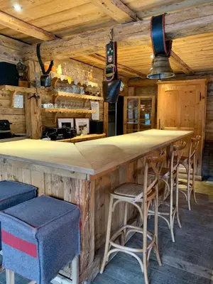 a bar in a log cabin with stools at Chalet familial et chaleureux in Les Contamines-Montjoie