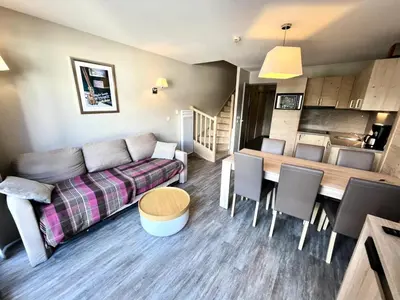 a living room with a couch and a table and a kitchen at Résidence Le Panoramic - Appartement lumineux · Départ et retour skis aux pieds · Piscine · Parking inclus · Spa · wifi MAE-0351 in Magland