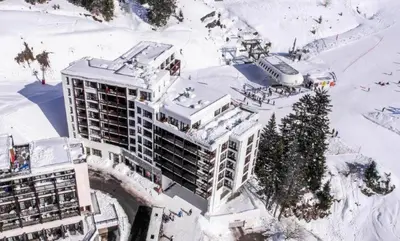 an aerial view of a building in the snow at Résidence Le Panoramic - Appartement lumineux · Départ et retour skis aux pieds · Piscine · Parking inclus · Spa · wifi MAE-0351 in Magland