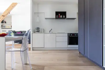 a kitchen with white cabinets and a table and chairs at Le Majestic 145 Apartment - Chamonix All Year in Chamonix-Mont-Blanc