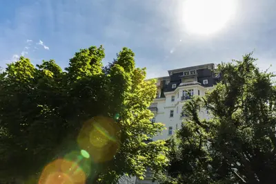 a tall white building with trees in front of it at Le Majestic 145 Apartment - Chamonix All Year in Chamonix-Mont-Blanc