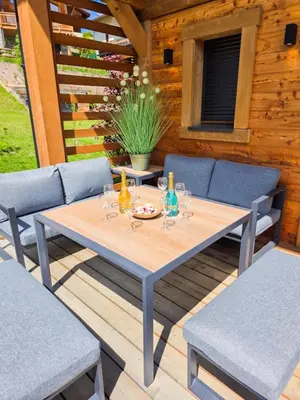 a table with wine glasses on a wooden deck at Chalet Combloran in Combloux