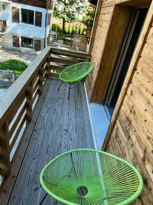 two green chairs sitting on a wooden deck at Private Loft Apartment, Central Chamonix in Chamonix-Mont-Blanc