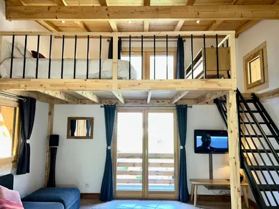 a loft bed in a room with a tv at Private Loft Apartment, Central Chamonix in Chamonix-Mont-Blanc