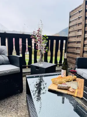 a table with a plate of food and a bottle of wine at Appartement Vu Mont Blanc parking Terrasse in Chamonix-Mont-Blanc