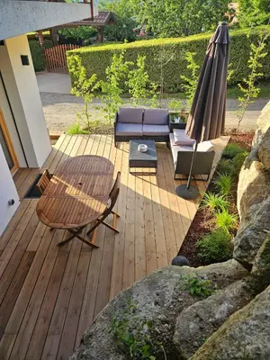 a patio with a table and a couch and an umbrella at Apartment in Saint-Gervais close to gondola in Saint-Gervais-les-Bains