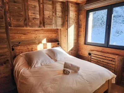 a bedroom with a bed in a wooden cabin at Reflets de Megève in Megève