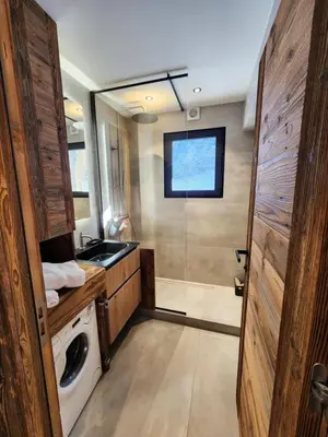a bathroom with a sink and a washing machine at Reflets de Megève in Megève