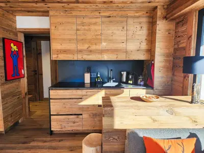 a kitchen with wooden cabinets and a counter top at Reflets de Megève in Megève