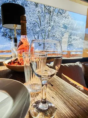 a table with two wine glasses and a bottle of wine at Reflets de Megève in Megève