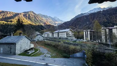 a town with a train track and mountains in the background at Appartement Avec Sauna in Chamonix-Mont-Blanc