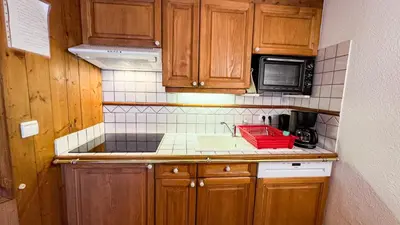 a small kitchen with a sink and a microwave at Appartement Avec Sauna in Chamonix-Mont-Blanc