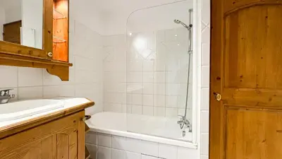 a bathroom with a tub and a sink and a shower at Appartement Avec Sauna in Chamonix-Mont-Blanc
