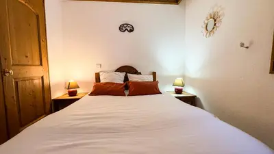 a bedroom with a large white bed with two lamps at Appartement Avec Sauna in Chamonix-Mont-Blanc