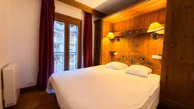 a bedroom with a white bed and a window at Appartement Avec Sauna in Chamonix-Mont-Blanc