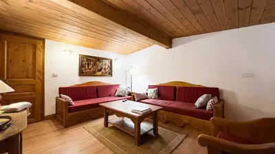 a living room with two red couches and a table at Appartement Avec Sauna in Chamonix-Mont-Blanc