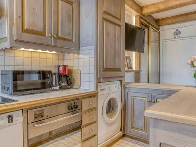 a kitchen with wooden cabinets and a washer and dryer at Appartement Pratique Centre Megève - 4 Pers - Animaux Bienvenus - FR-1-453-324 in Megève