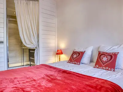 a bedroom with a large bed with red pillows at Appartement Pratique Centre Megève - 4 Pers - Animaux Bienvenus - FR-1-453-324 in Megève