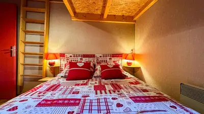 a bedroom with a bed with red pillows at Appartement Proche Des Pistes in Saint-Gervais-les-Bains