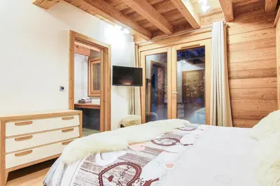 a bedroom with a bed and a television in a room at Chalet La Petite Forêt in Megève