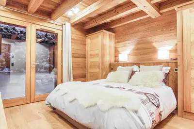 a bedroom with a bed in a wooden cabin at Chalet La Petite Forêt in Megève