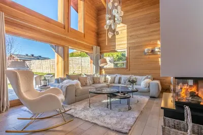 a living room with a couch and a fireplace at Chalet La Petite Forêt in Megève