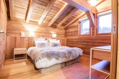 a bedroom with a bed in a wooden cabin at Chalet La Petite Forêt in Megève