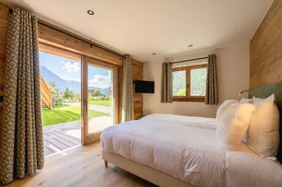 a bedroom with a bed and a large window at Chalet Angel - Chamonix in Chamonix-Mont-Blanc