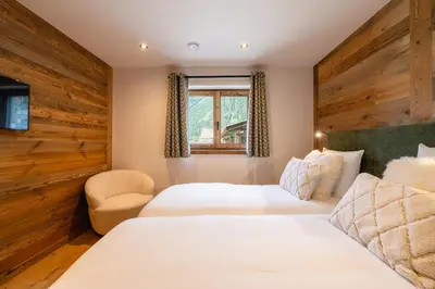 a hotel room with two beds and a window at Chalet Angel - Chamonix in Chamonix-Mont-Blanc