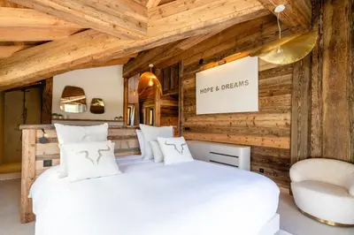 two beds in a room with wooden walls at Chalet Angel - Chamonix in Chamonix-Mont-Blanc