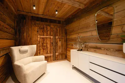 a living room with wooden walls and a chair at Chalet Angel - Chamonix in Chamonix-Mont-Blanc