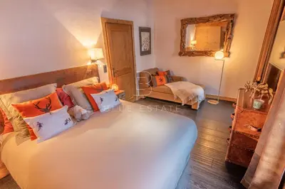 a bedroom with a bed in a room with wooden walls at Chalet Le Hameau - Megève in Demi-Quartier