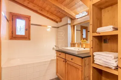 a bathroom with a tub and a sink and a tub and a mirror at Chalet Le Hameau - Megève in Demi-Quartier