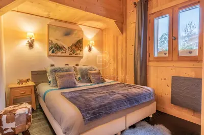 a bedroom with a large bed with orange pillows at Chalet Le Hameau - Megève in Demi-Quartier