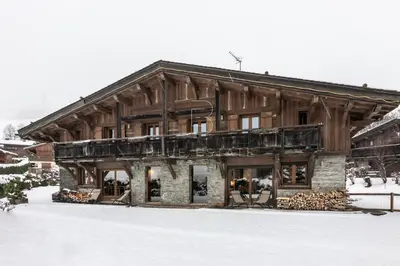 a bedroom with a bed and a large window at Chalet Le Hameau - Megève in Demi-Quartier