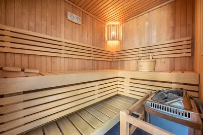 a sauna with a tub and a sink in it at Chalet Le Chardon Bleu in Megève