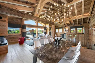 a dining room with a marble table and white chairs at Chalet Le Chardon Bleu in Megève