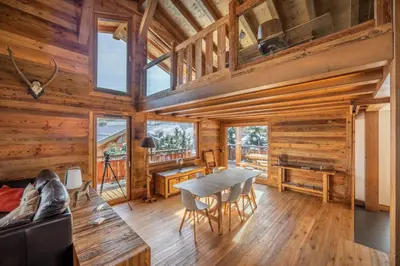 a dining room with a table and chairs in a cabin at Chalet Les Marmottes in Combloux