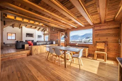 a dining room and living room with a table and chairs at Chalet Les Marmottes in Combloux