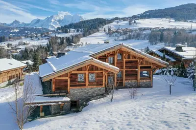 a log cabin in the snow with mountains at Chalet Les Marmottes in Combloux